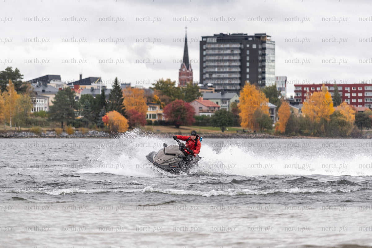 Person riding a jet ski on a lake in autumn