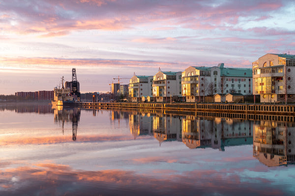 Harbor waterfront with residential buildings at sunrise