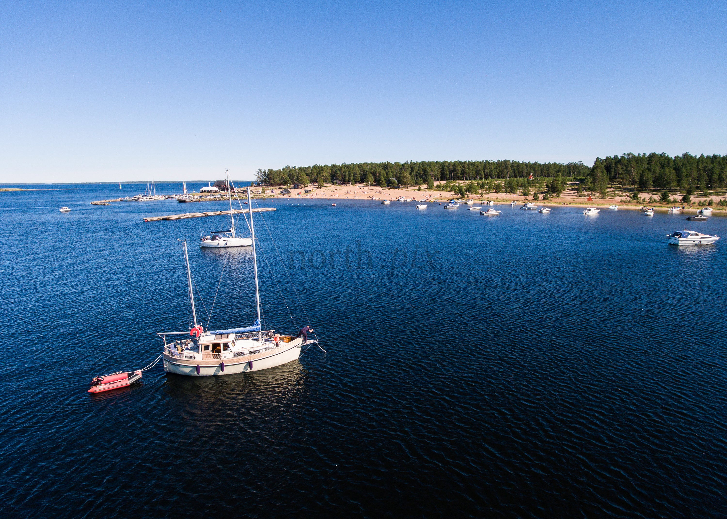 Drone Shot of Boats Anchored by a Sandy Beach During a Summer Day