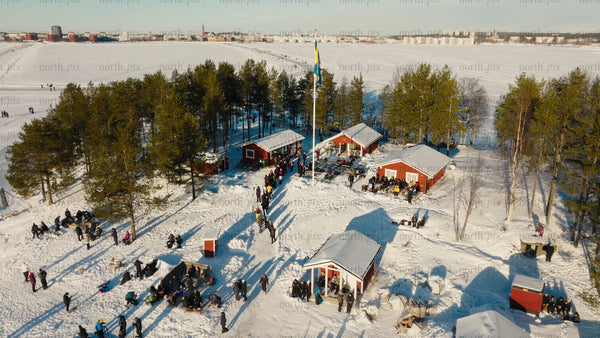 Winter fun in Luleå: Aerial view of ice skating, snowmobiling, and sledding on a frozen lake