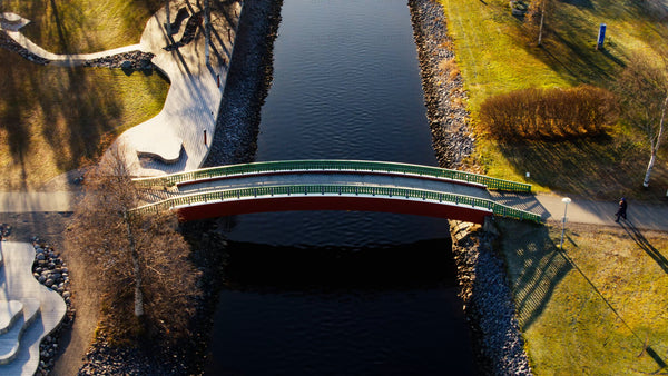 Autumn aerial view: Person walking across a bridge over Piteå city canal