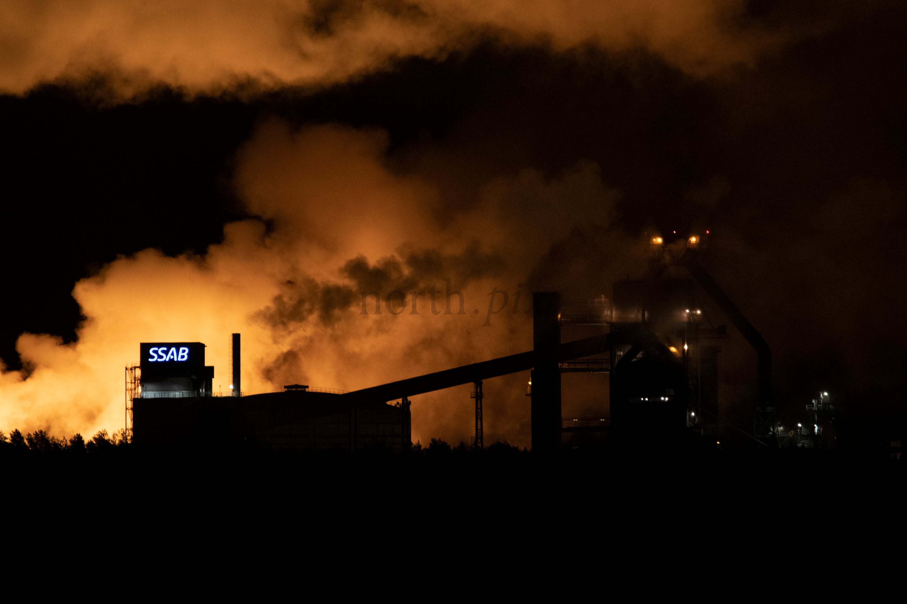 SSAB steel plant exterior at night with smoke
