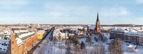 Snow-covered city panorama with tall church steeple