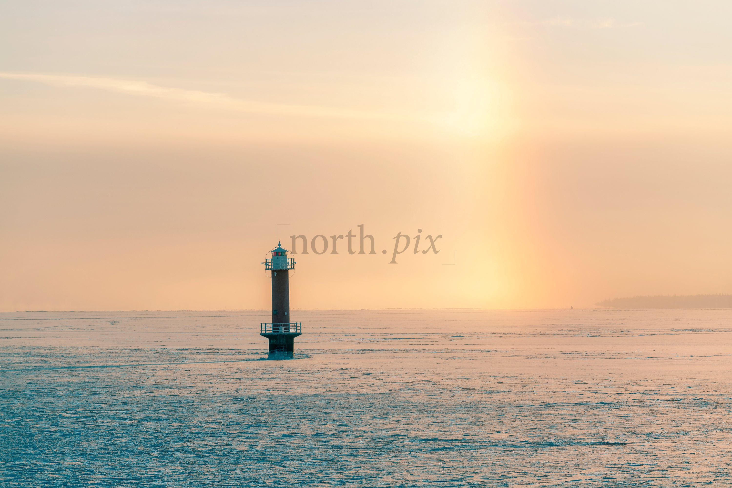 Lighthouse on frozen sea at sunrise