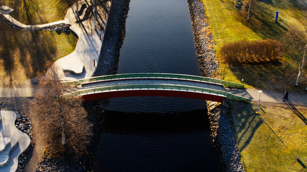 Autumn aerial view: Person walking across a bridge over Piteå city canal