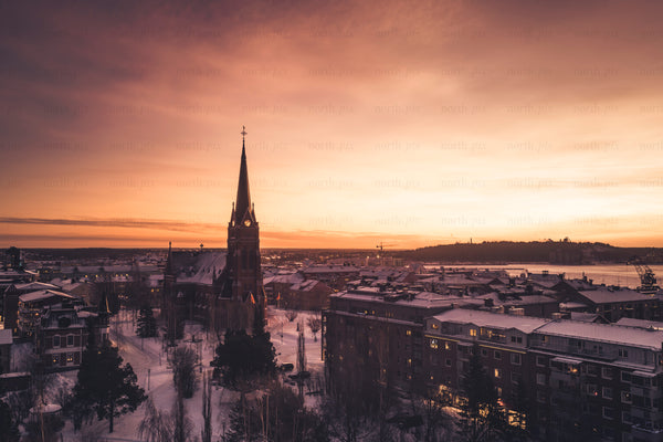 Church steeple over snowy city at sunrise