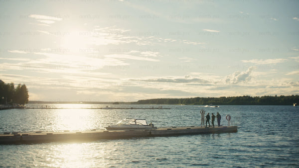 Friends enjoying sunset on a dock in Luleå
