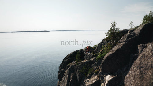 Drönarvy över klippig klippa och båt i Luleå skärgård, Sverige, på ljus sommardag