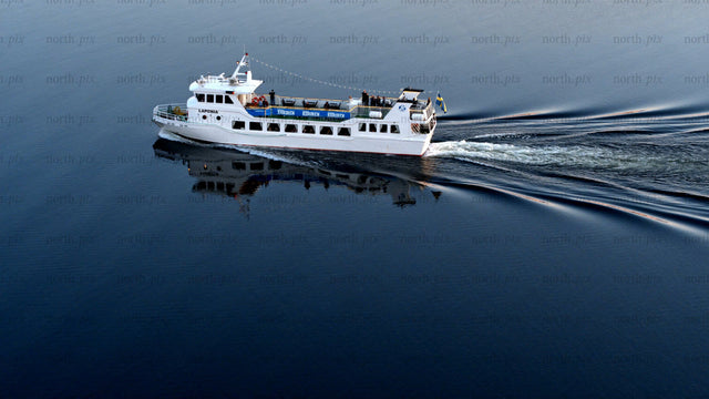 White passenger ferry sails on the Luleälven in Luleå on a summer day