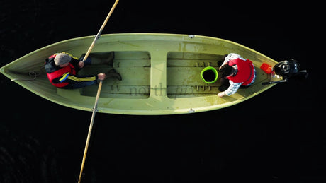 Two Men Rowing a Boat on a Dark, Still Lake in Lulea, Sweden, Summer Day