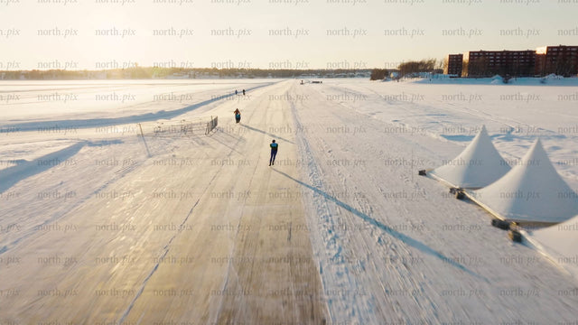 Ice skater on frozen track in Luleå during a bright winter day - drone footage