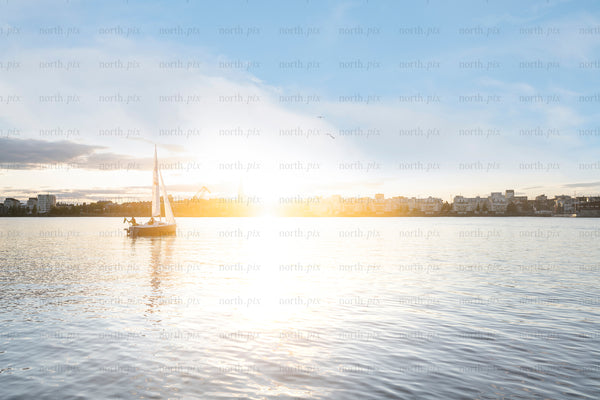 Sailboat on harbor water at sunrise