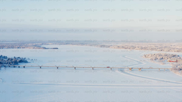 Winter Sunrise Over Frozen River and Bridge in Luleå, Sweden