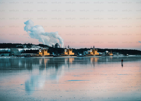 Winter evening in Luleå harbor with industrial ships and skating activity