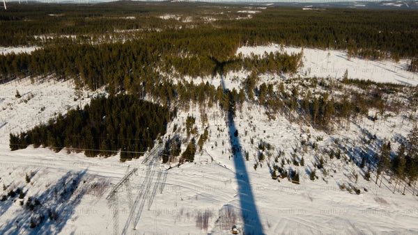 Aerial view of wind turbine in snowy forest