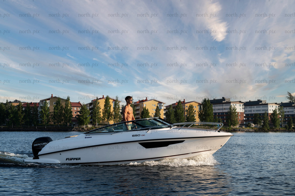 Man driving motorboat on river at sunset