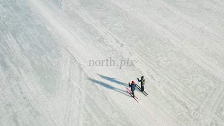 Aerial View of Cross-Country Skiers on Frozen Lake in Luleå, Sweden, Winter Day