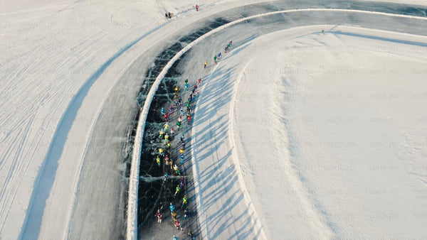 Drone view of ice skating marathon on frozen lake in Luleå