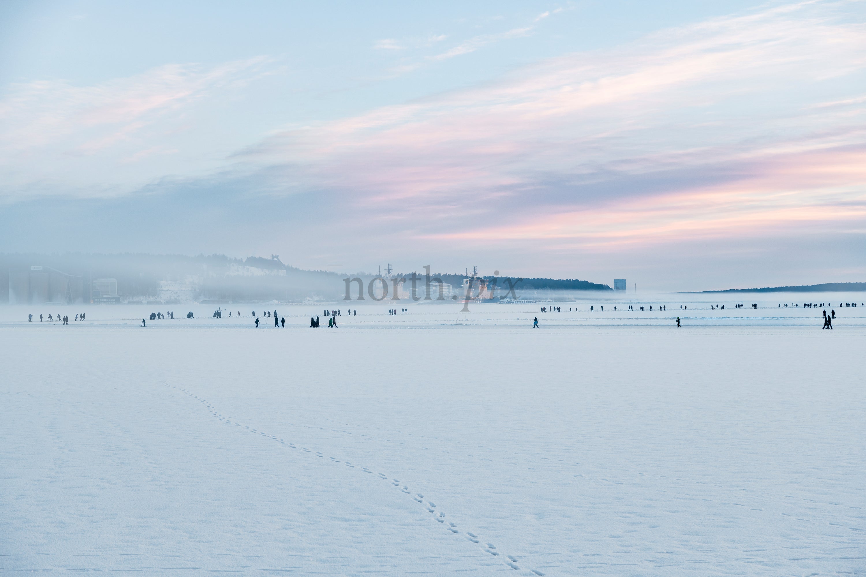 People on frozen sea at sunrise, winter