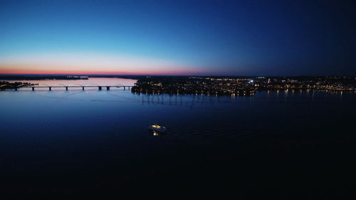 Flygfoto över Luleå, Sverige vid solnedgången med båt, bro och stadsljus