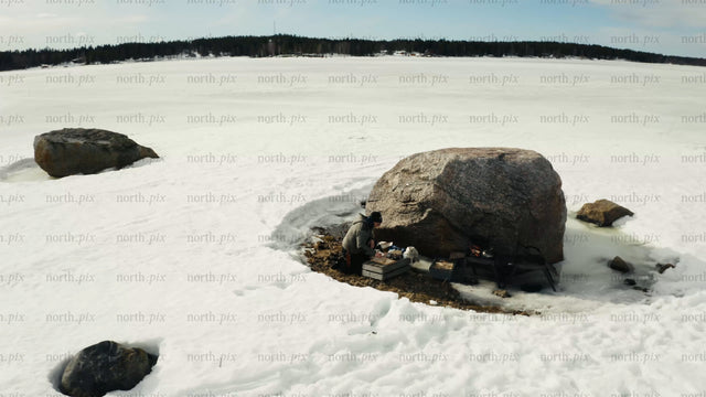 Winter in Luleå: Aerial drone view of person by frozen lake and snowmobile