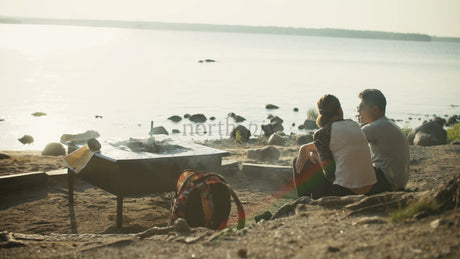 Couple Enjoys Summer Evening by Campfire on Beach in Lulea, Sweden