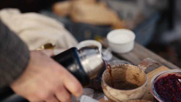 Winter picnic in the Luleå archipelago: Pouring a hot drink into a kuksa mug