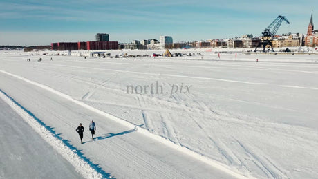 Winter in Luleå: Two People Running on a Frozen Water Track