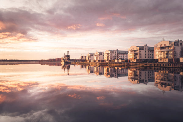 Waterfront apartment buildings "tuttifrutti" reflected in calm sunset water