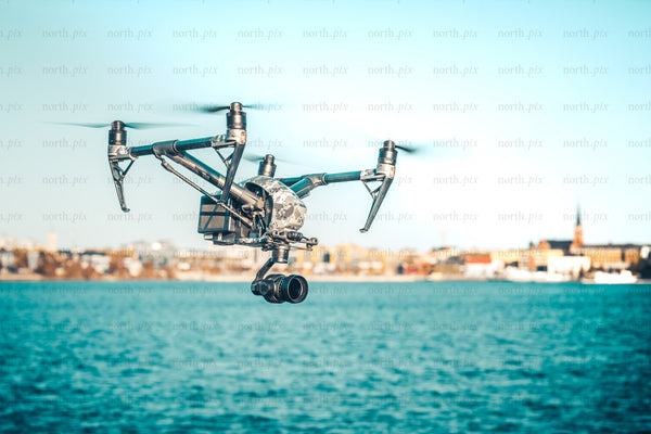 Drone camera flying over waterfront city at midday