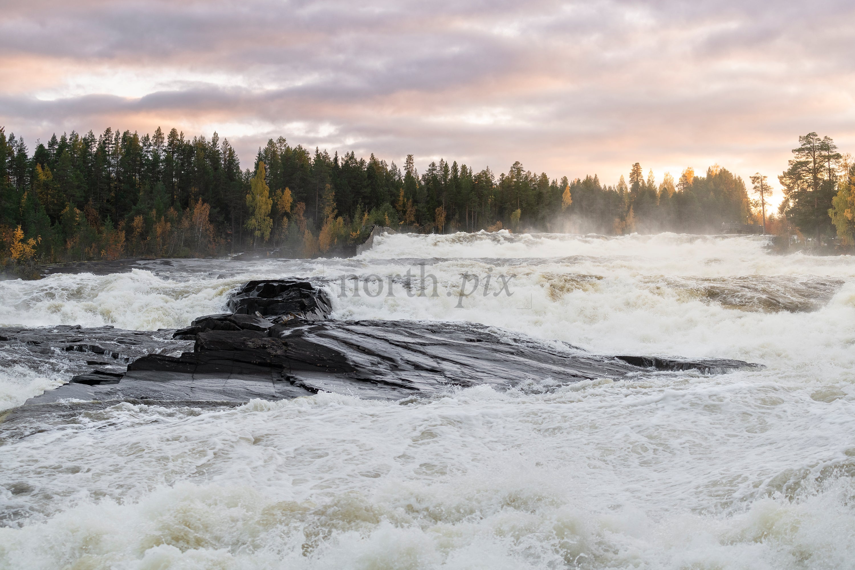 River rapids flowing over rocks at sunrise