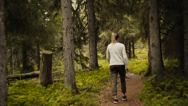Woman walks through summer forest in Luleå
