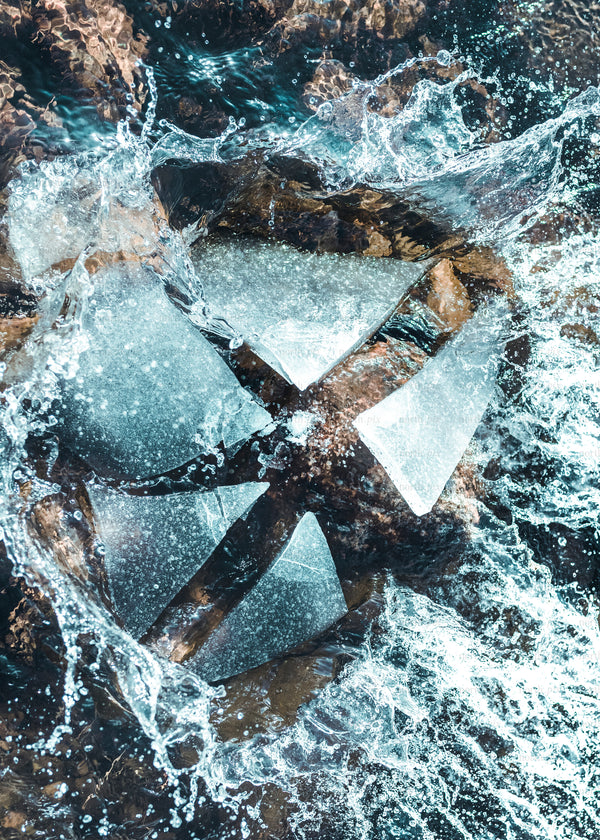 Metal water wheel with splashing water over rocks