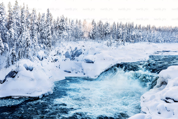 Jokkfall waterfall in snowy winter forest landscape