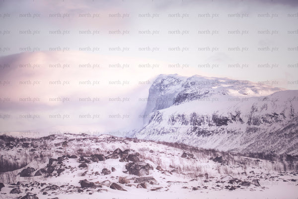 Stora sjöfallet - snow-covered mountain at sunrise with rocky foreground