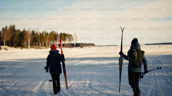 Winter skiing adventure: Two people walking across frozen Luleå archipelago