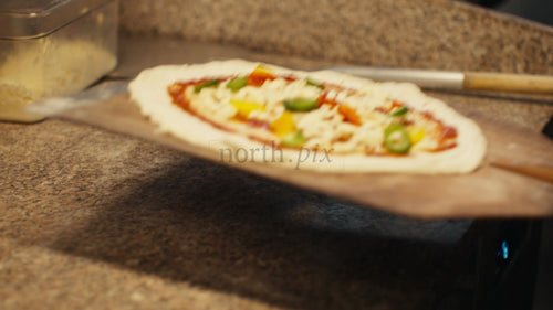 Kocken lägger pizza i vedeldad ugn, närbild