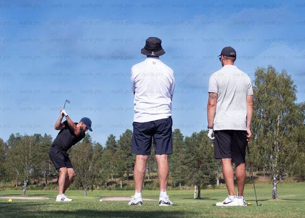 Three men playing golf on a course in summer
