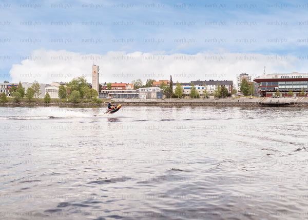 Jet ski on river near waterfront buildings in summer