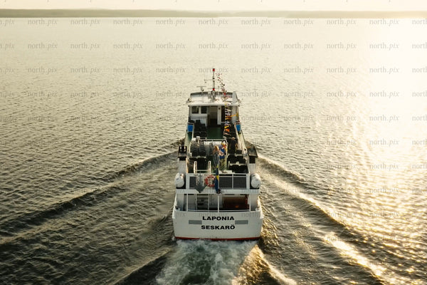 Passenger ferry boat tour on calm water at sunset near Luleå city center