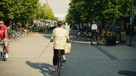 Woman on Bicycle Rides Through Lulea City Center on a Sunny Summer Day