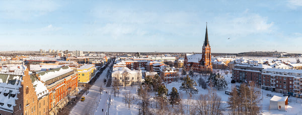 Snow-covered city panorama with tall church steeple
