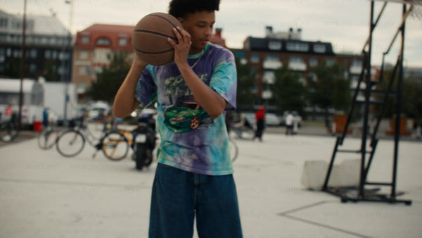 Young men playing one-on-one basketball on an urban court in Luleå