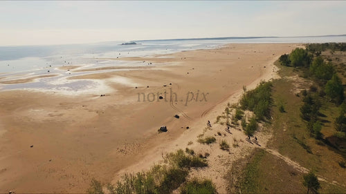 Fat biking on a sandy beach in Luleå, summer day drone shot