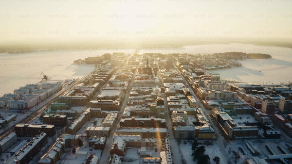 Aerial sunrise over snow-covered Luleå city center in winter