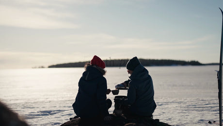 Winter Day in Luleå Archipelago: Two People Enjoy a Warm Drink by a Frozen Lake