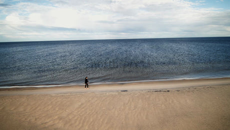 Woman Walking on Sandy Beach by the Sea in Summer