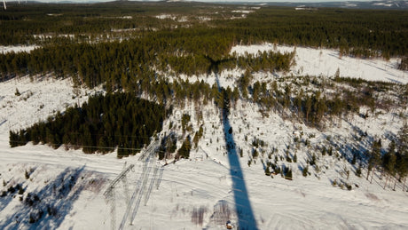 Aerial View of Wind Turbine in Snowy Forest: Winter Energy