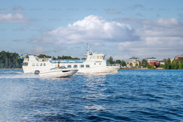 White passenger ferry and speedboat on water in summer