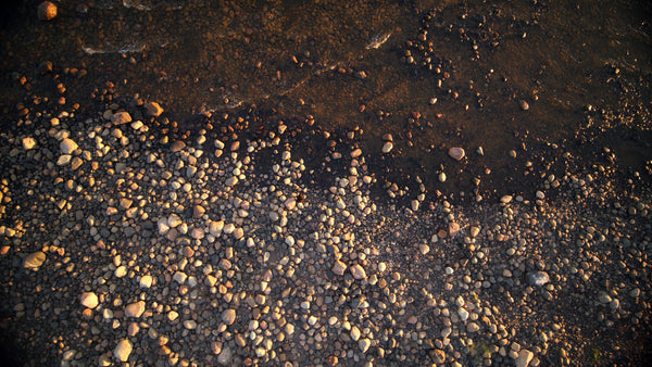 Summer evening drone shot: Waves gently washing over rocks in the rödkallen archipelago, Luleå